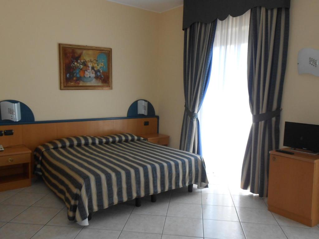 a bedroom with a bed and a large window at Albergo Villa Eva in Costermano