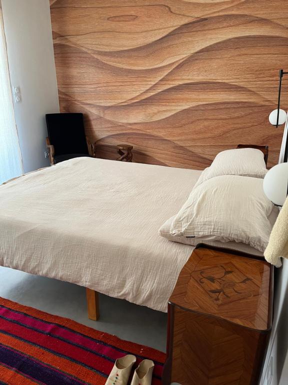 una camera da letto con un letto con una parete in legno di Magnifique villa écologique piscine jacuzzi a Clarensac
