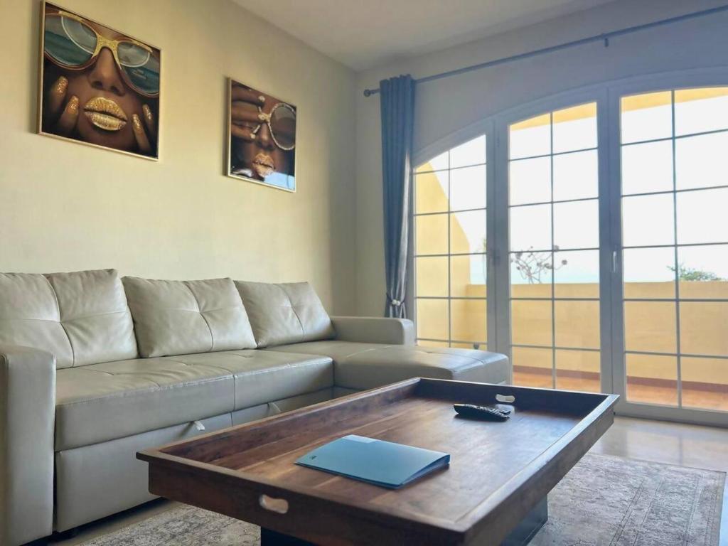 a living room with a couch and a coffee table at Espacioso apartamento en Mijas con parking privado in Sitio de Calahonda