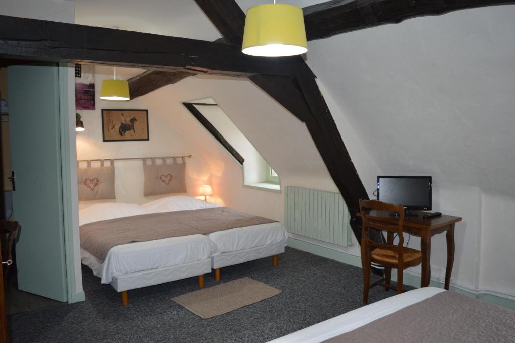 una camera con letto e scrivania con TV di Le Relais du Morvan a Vézelay