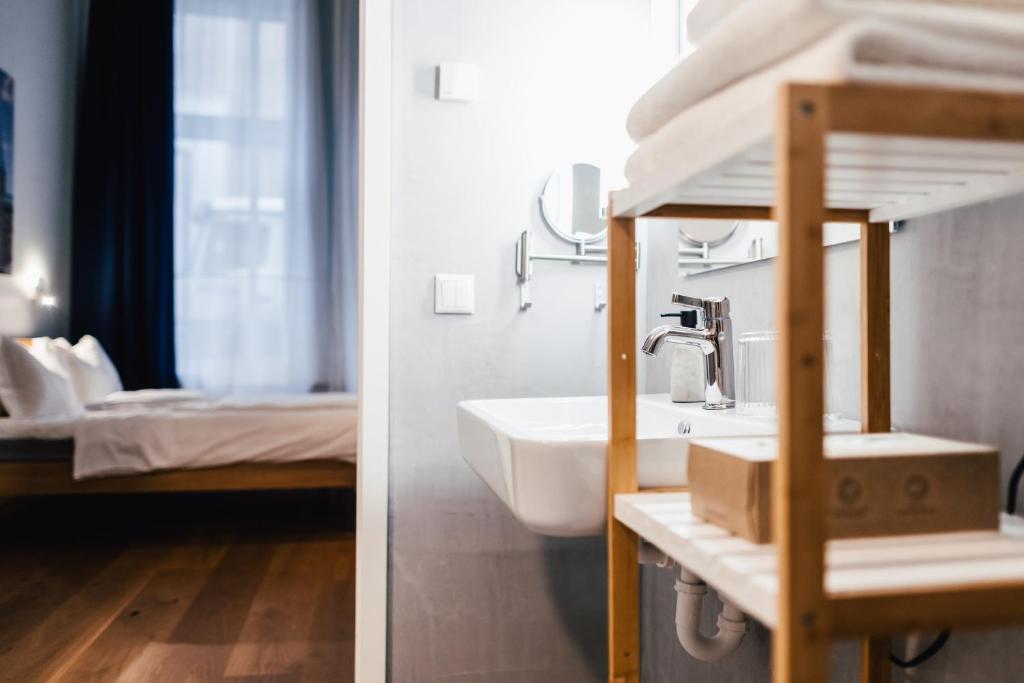 a bathroom with a sink and a bedroom with a bed at The Layhead B&B in Lübeck
