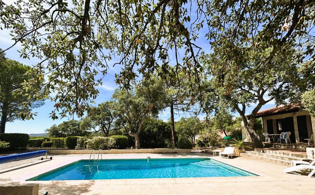 une piscine devant une maison dans l'établissement Le Plantier, maison pour 6 personnes avec piscine et jardin vue mer à La Londe-Les-Maures, à La Londe-les-Maures