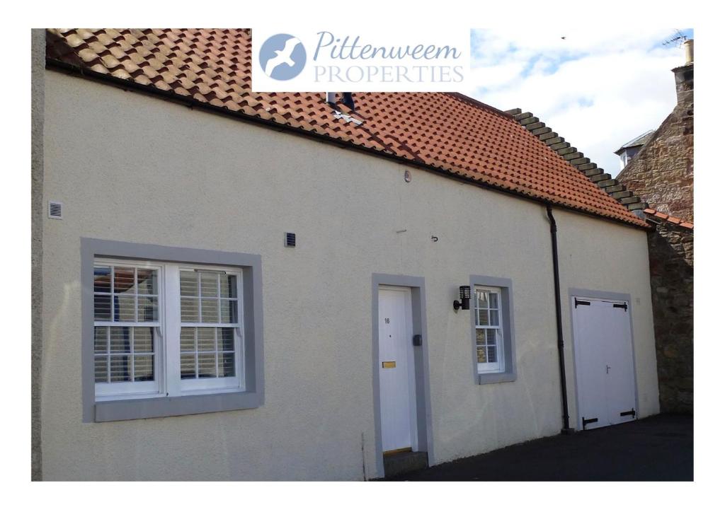 a white building with two windows and a roof at Seaglass Cottage-family friendly home in East Neuk in Pittenweem