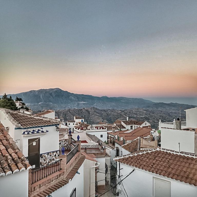 a view of the roofs of a town at sunset at La Biznaga - Comares in Comares