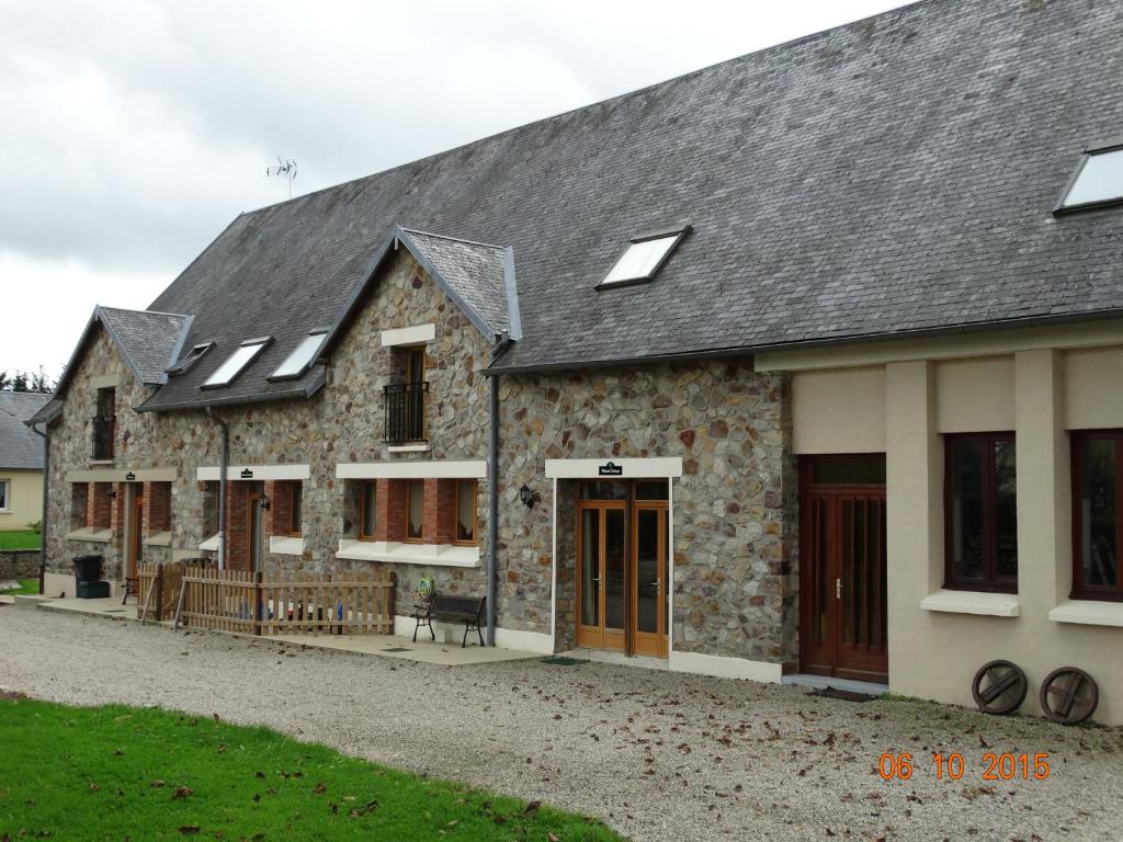 une maison en pierre avec un toit gris et des fenêtres dans l'établissement Les Gîtes Champêtres OAK Cottage, à Sainteny