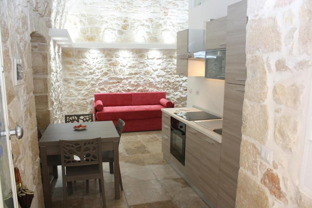 cocina con sofá rojo y mesa en Lilla B&B Luxury Apartments, en Molfetta