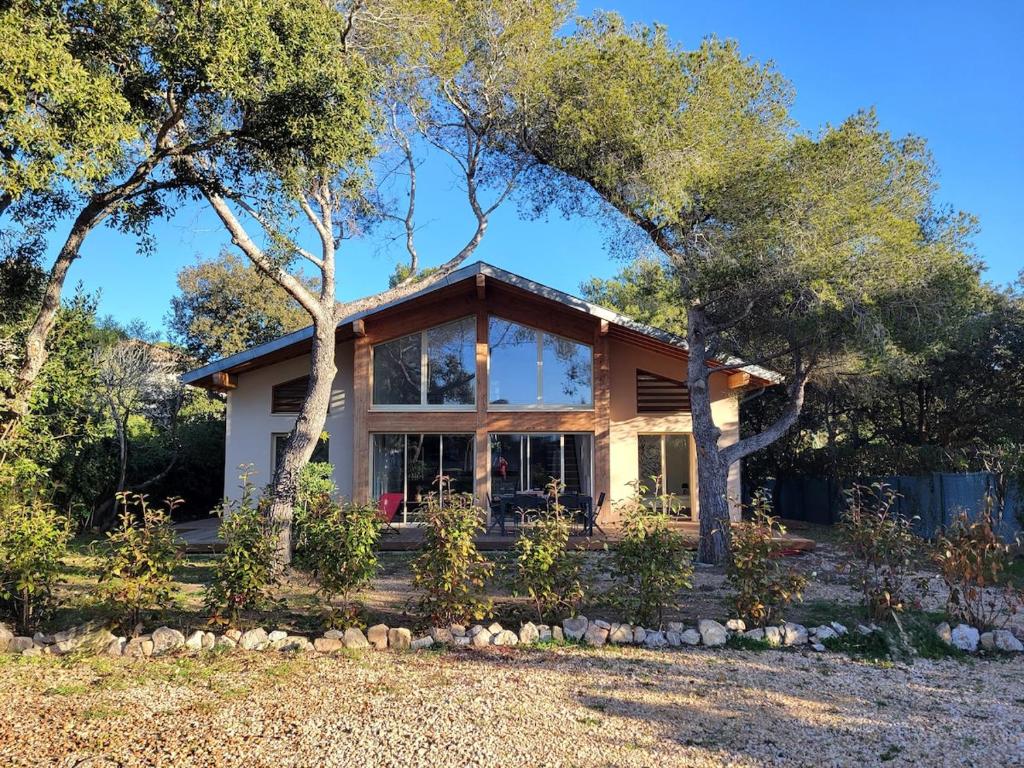 une maison avec une grande fenêtre et des arbres dans l'établissement Villa Lou Pantaï la tranquillité à 2 pas de la mer, à Saint-Aygulf