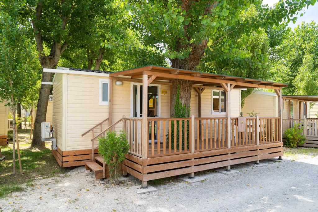 a tiny house with a porch and a deck at Club del Sole Rimini Family Resort in Rimini