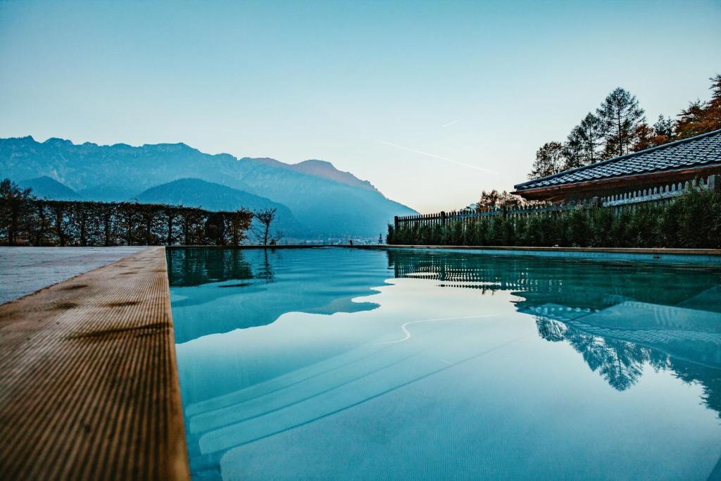 a pool of water with mountains in the background at Luxus Ferienhaus Salzburg Chalet mit Pool, Sauna, Whirlpool, Kamin in Grossgmain