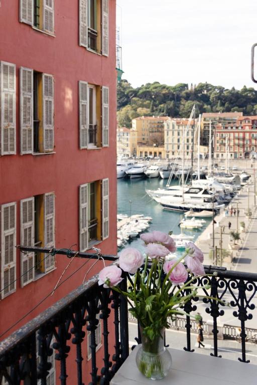 un vase de fleurs sur un balcon avec un port de plaisance dans l'établissement Seabreeze Apt Nice Port, à Nice