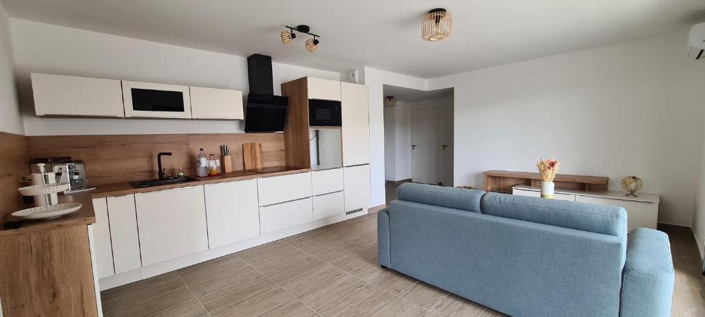 un salon avec un canapé bleu dans une cuisine dans l'établissement Appartement 4 pers en résidence, à Propriano
