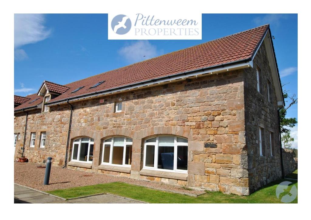 a brick building with windows on the side of it at Seaview Steading-spacious home in rural location in Crail