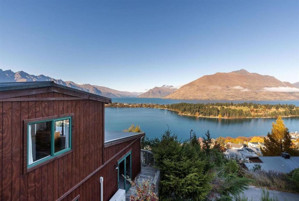 ein Haus mit Blick auf einen See und die Berge in der Unterkunft Lakeview Treehouse at Queenstown Hill in Queenstown