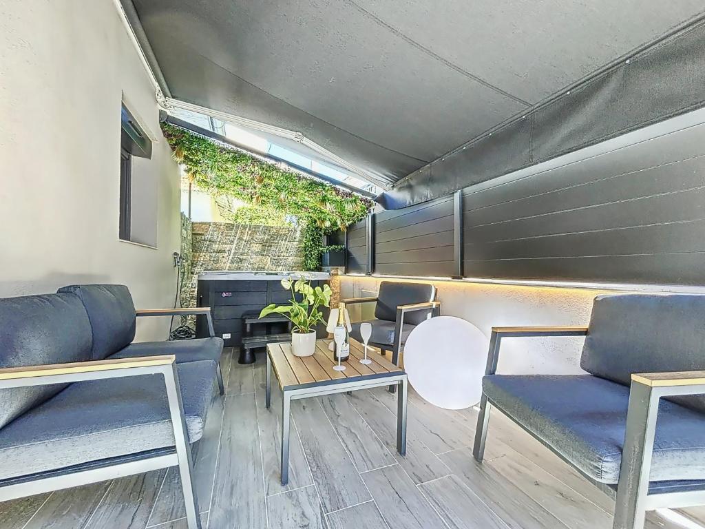 un salon avec des chaises bleues et une table dans l'établissement La Suite EDEN - Maison de ville Luxe - 4pers - Jacuzzi - 10min Cannes, au Cannet