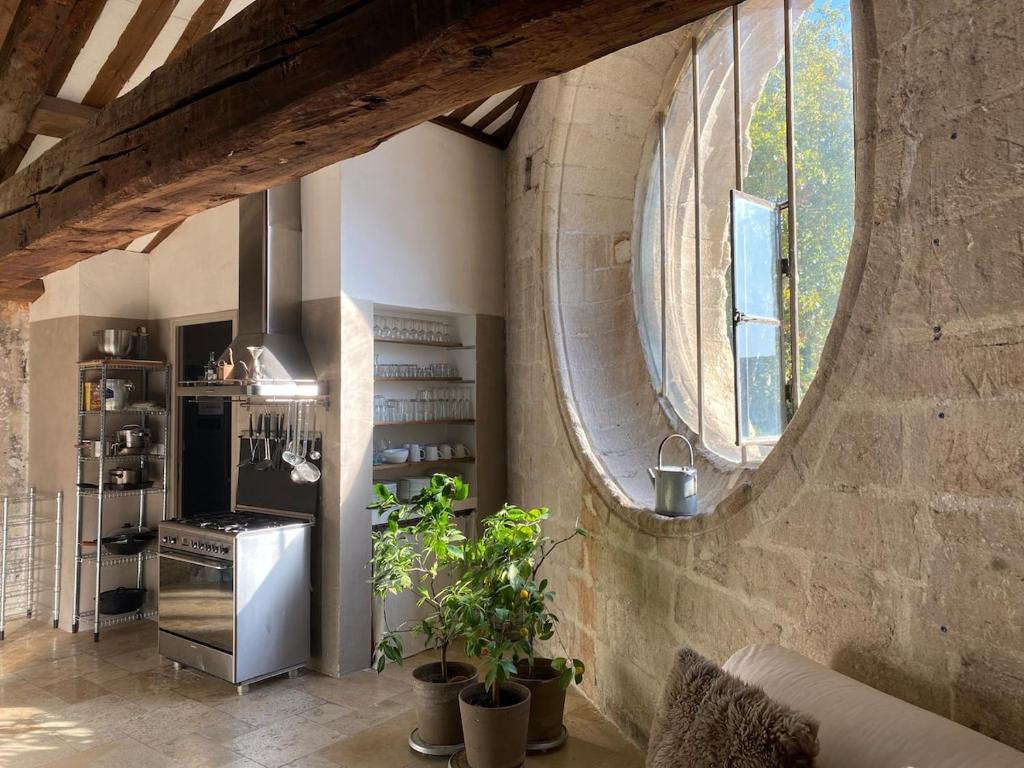 une cuisine avec un mur en pierre et une grande fenêtre dans l'établissement Dormir dans une église du 13ème siècle au coeur d'Avignon, à Avignon