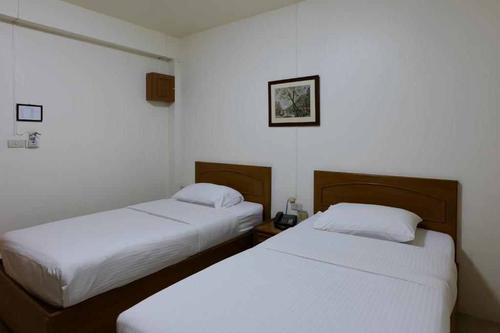 Postel nebo postele na pokoji v ubytování โรงแรมมูนแอนด์ซัน Moon and Sun Hotel