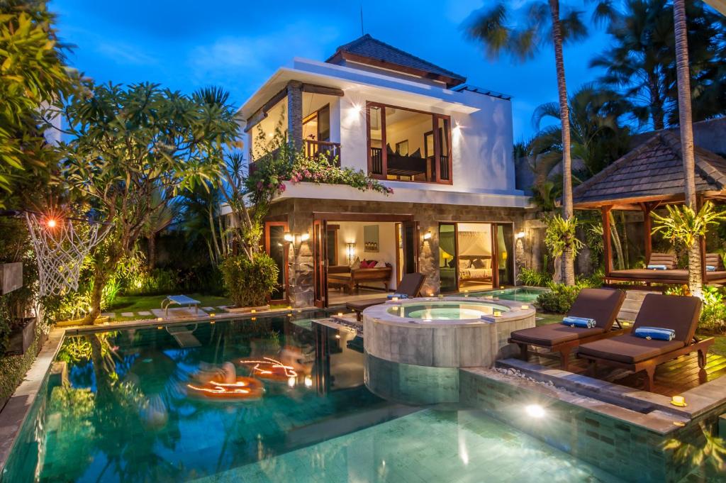 a villa with a swimming pool and a house at Villa Annecy in Seminyak