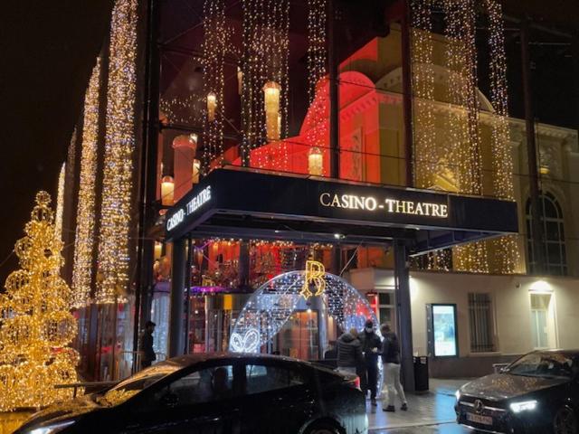 une voiture garée devant un magasin avec des lumières de Noël dans l'établissement STUDIO TOUT EQUIPE 50 M DE LA GARE D'ENGHIEN LES BAINs 15 MN DE PARIS CENTRE, à Enghien-les-Bains