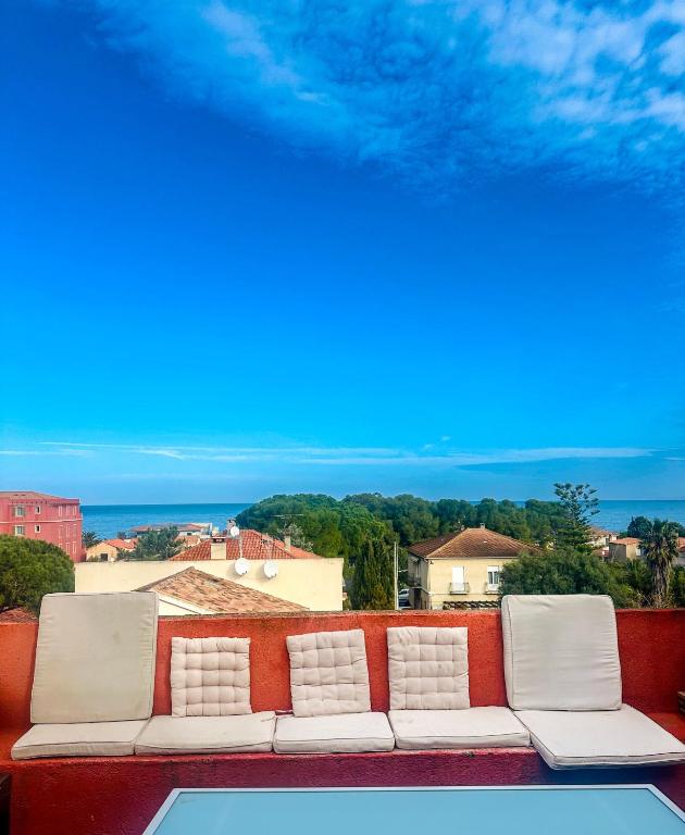 - un canapé installé sur un balcon avec vue sur l'océan dans l'établissement Beau loft en centre-ville vue mer, à LʼÎle-Rousse