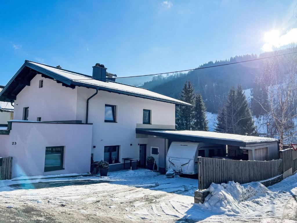 a white house in the snow with a fence at Apartment Stefanie by Interhome in Taxenbach