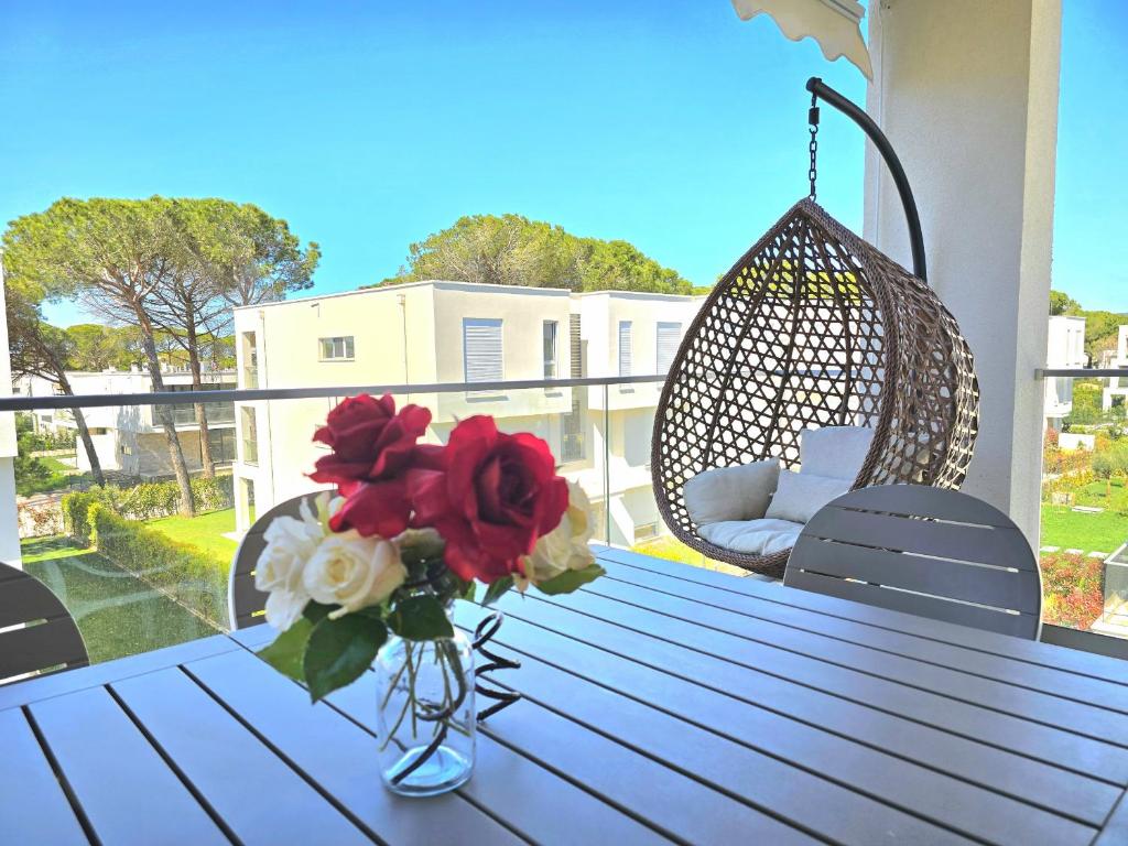 un vaso di fiori su un tavolo con un'altalena di SwissSweet Apartment - 297 a Durrës