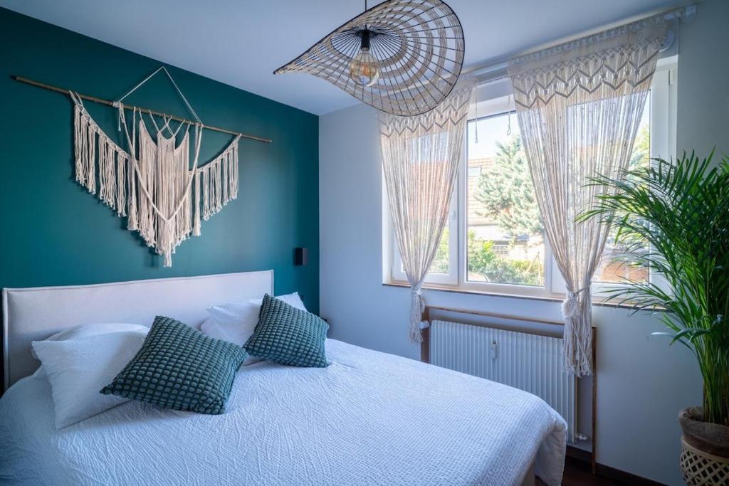 a bedroom with blue walls and a bed with pillows at Suite Zen - Calme et Lumière - 2 lits 160 cm - Parking privé résidence in Sélestat