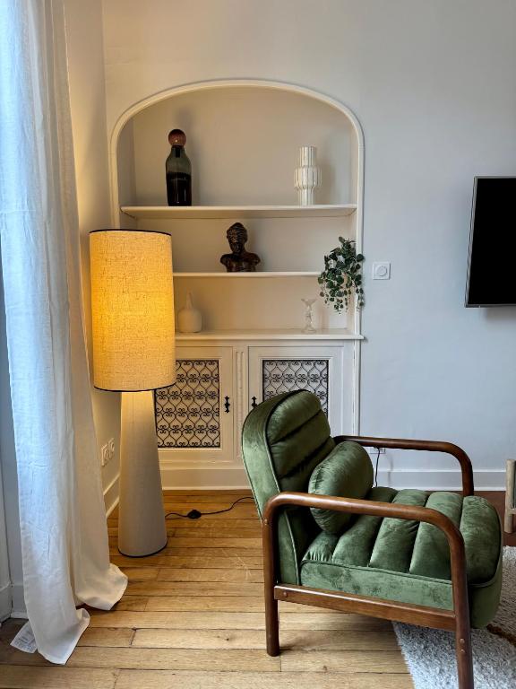 un salon avec une chaise verte et une lampe dans l'établissement Les Lys d'Or, à Saumur