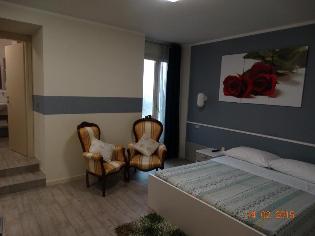 una camera con un letto e due sedie di Hotel Moderno a Grumello del Monte
