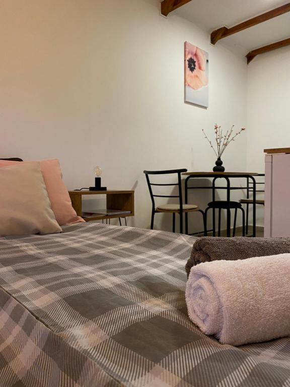a bedroom with a bed and a table with chairs at Altiora in Subotica