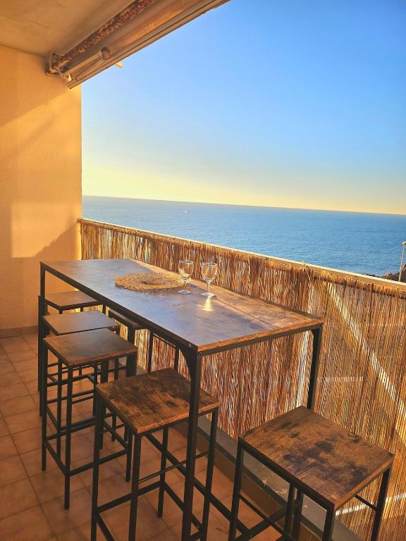 une table et des chaises sur un balcon avec l'océan dans l'établissement LE MARTY 46, Jolie Déco, Vue Mer, Climatisation, Parking Privé, Piscine, à Sète