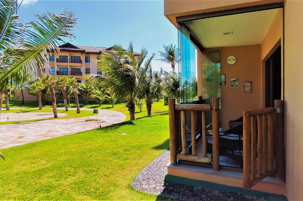 a view of a house with a yard with palm trees at VG Sun Cumbuco Térreo WiFi Ar Cond 4 Pessoas in Paracumbuca