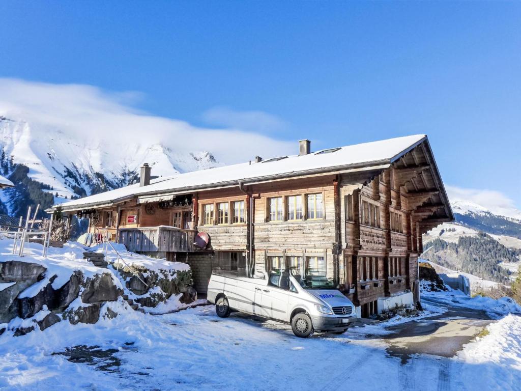 a truck parked in front of a house in the snow at Apartment Bühl by Interhome in Achseten