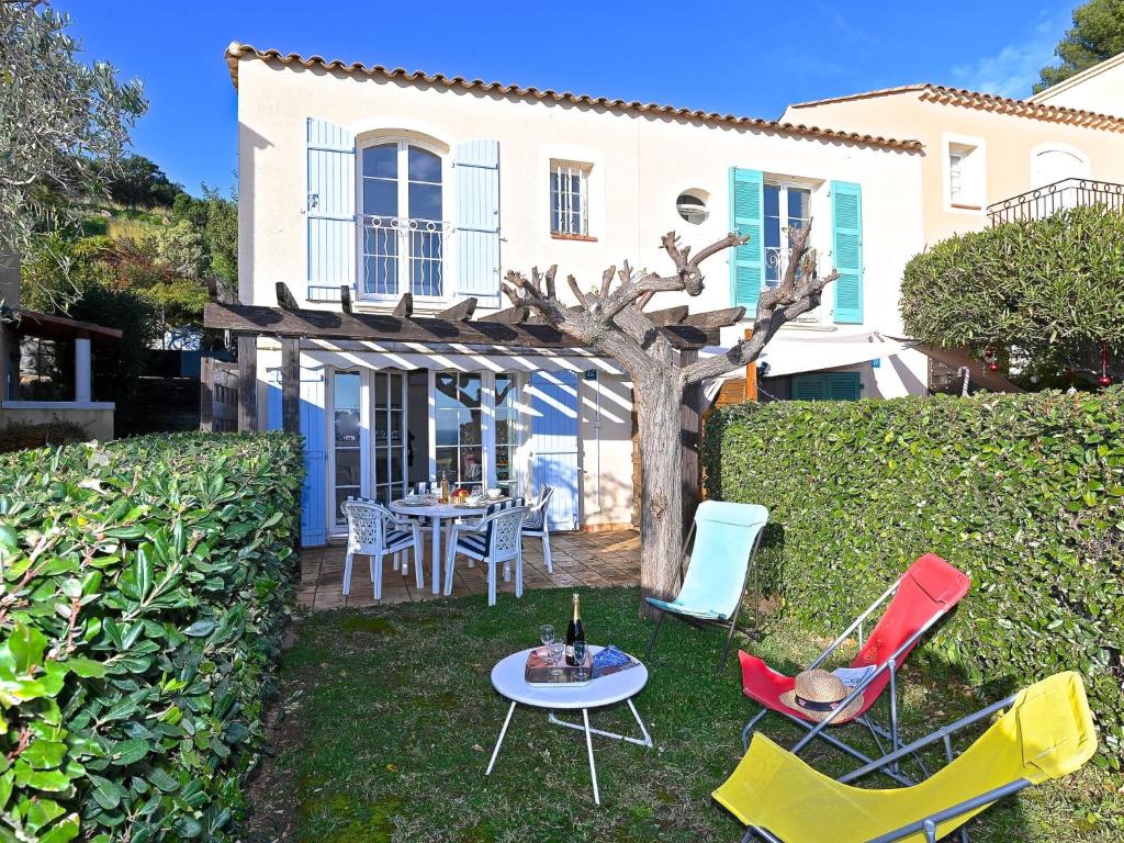 Holiday Home Village Cap Estérel - Le Hameau-36 by Interhome في Drammont: حديقة فيها كراسي وطاولة امام المنزل