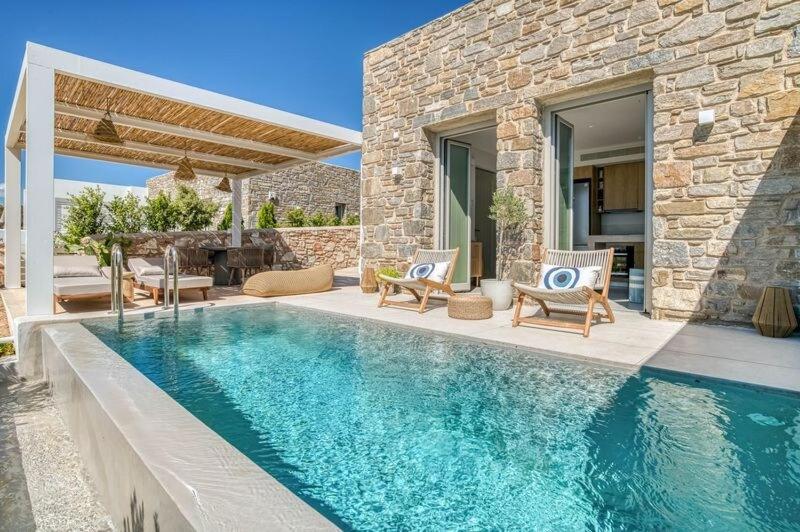a swimming pool in front of a stone house at Villa Gypsea - Paros in Aspro Chorio Paros