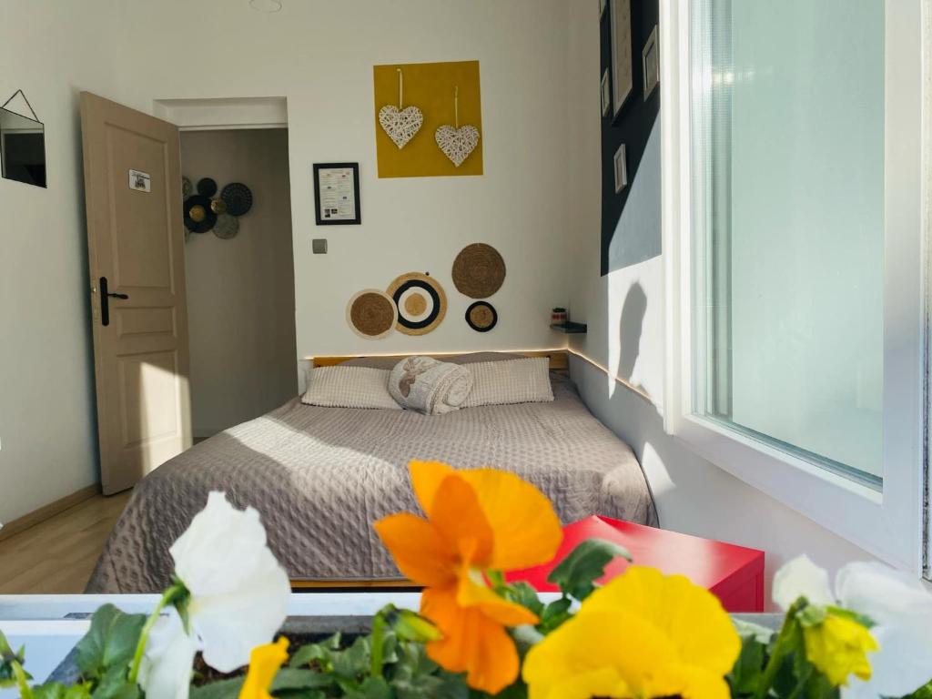 Un dormitorio con una cama y una mesa con flores. en Chambre privée au coeur de Calais, en Calais