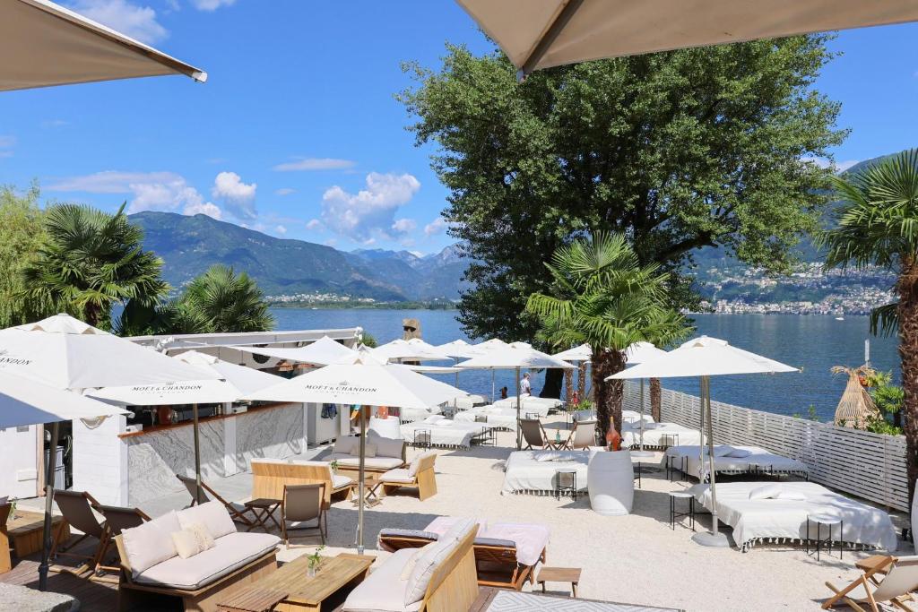 a patio with tables and chairs and umbrellas at Riva Boutique Hotel I Restaurant I Beach Club in Vira