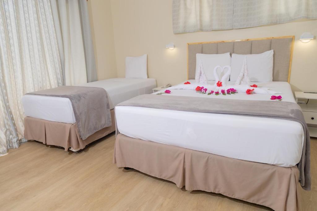 a hotel room with two beds with flowers on them at Crown Point Beach Hotel in Crown Point