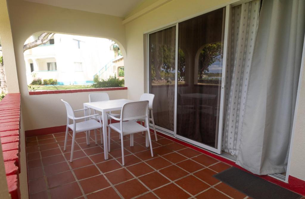 a balcony with a table and chairs and a window at Crown Point Beach Hotel in Crown Point