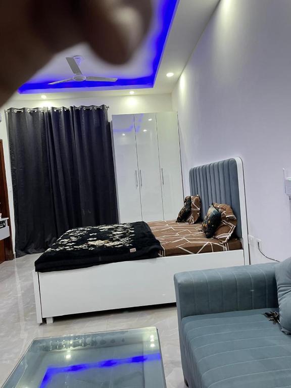 a room with a bed and a couch in it at Golden palace studio in Noida