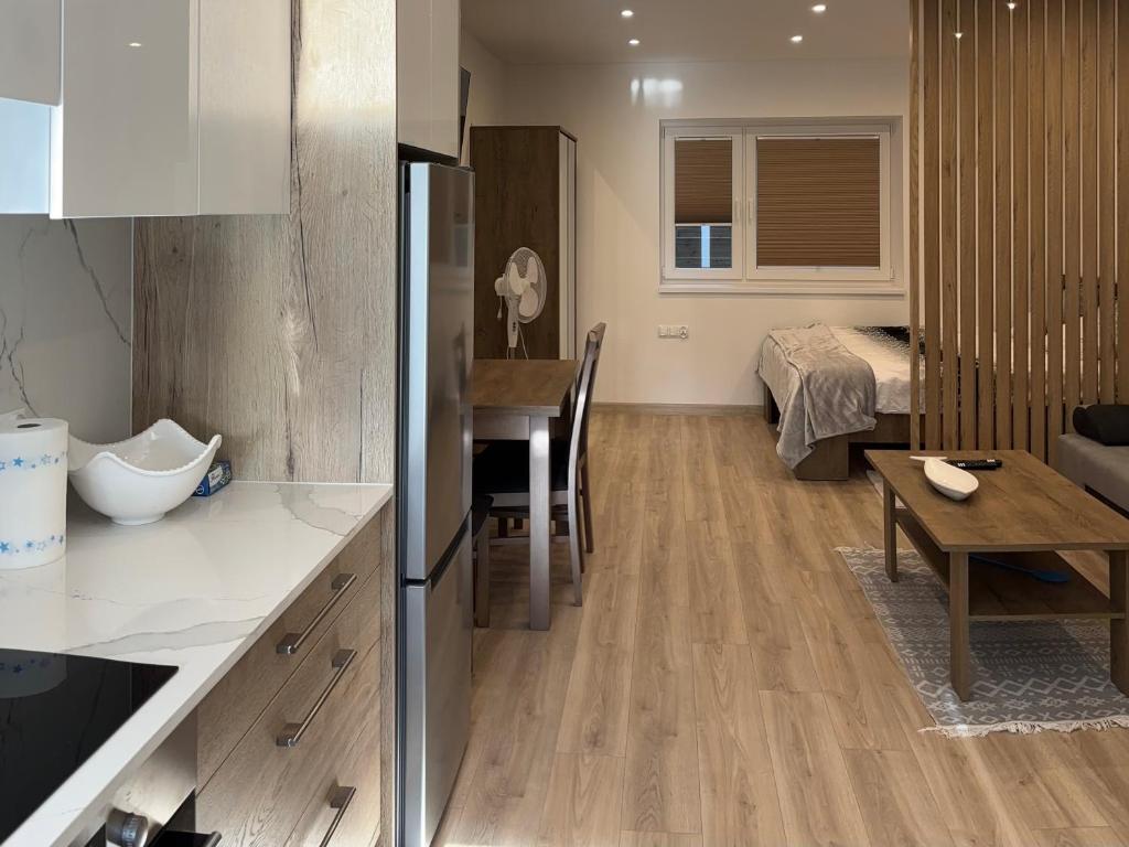 a kitchen and living room with a table and a couch at Apartamenty na Kowańcu 2 in Nowy Targ