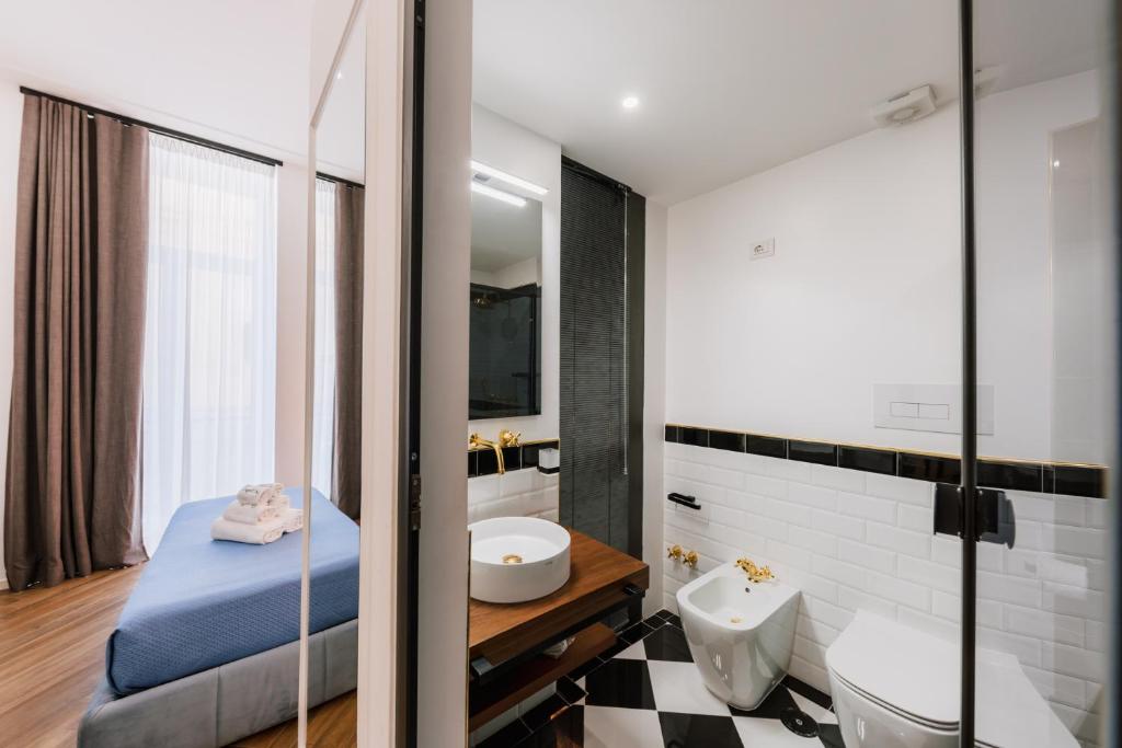 a bathroom with a bed and a sink and a mirror at Raggio di Sole in Maiori