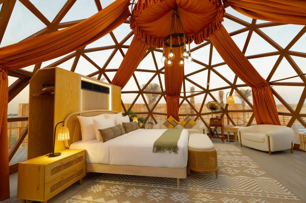 ein Schlafzimmer mit einem Bett in einem Zelt in der Unterkunft Al Marmoom Oasis Luxury Experiential Desert Domes in Dubai