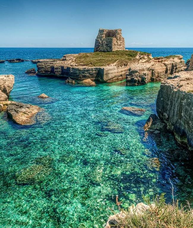 an island in the ocean with blue water and rocks at Monolocale SULE in San Foca