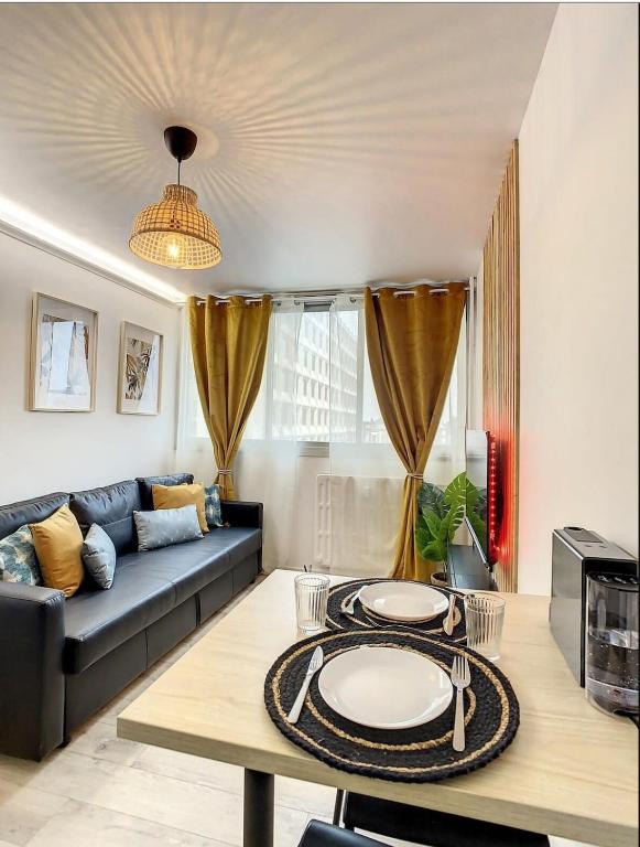 un salon avec un canapé et une table dans l'établissement L'Haneri - Center, WIFI - Comfort et Modern Style, à Amiens