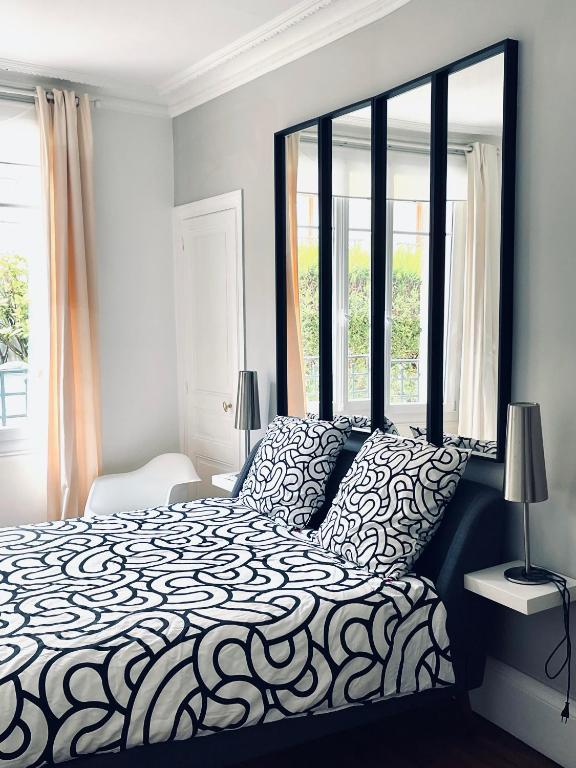 une chambre avec un lit noir et blanc et une fenêtre dans l'établissement Le Jardin Reims Cathedrale, à Reims