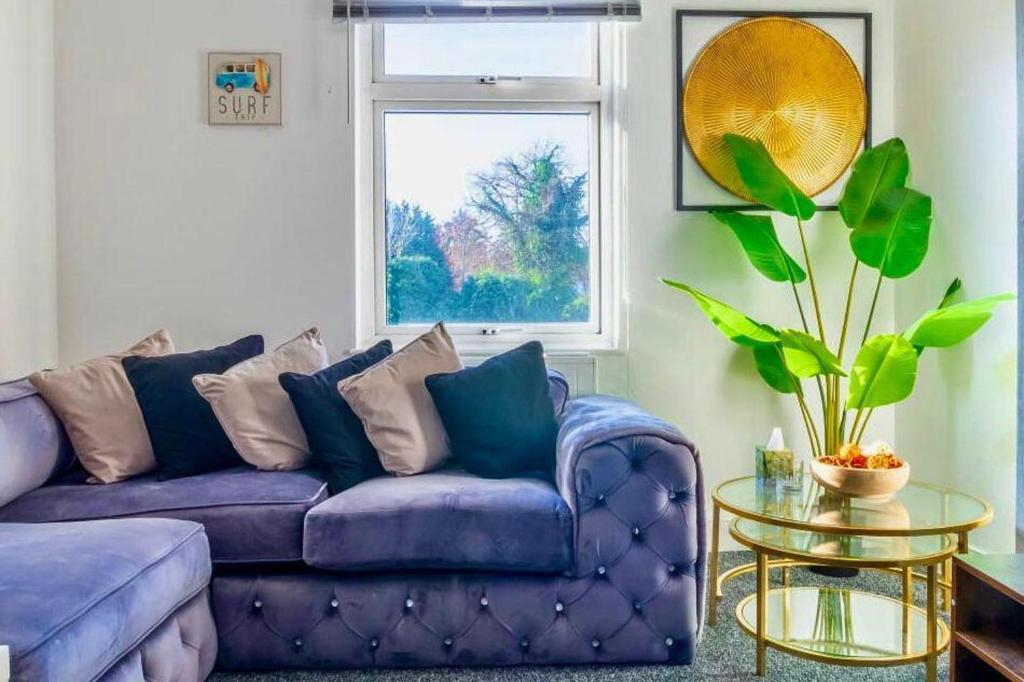 a purple couch in a living room with a window at Rayleigh Retreat-Spacious Family 3 Bed Apartment in Rayleigh