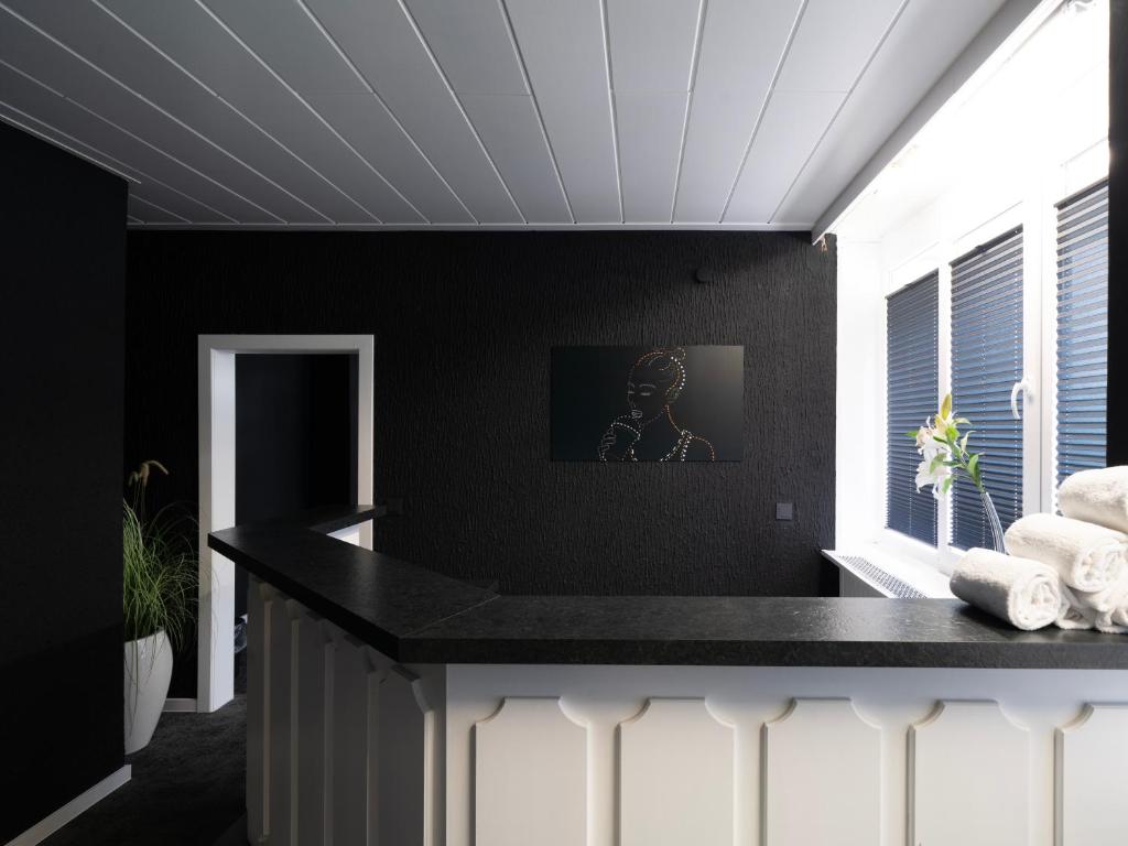 a kitchen with black walls and a counter with towels at JustStay Mülheim Hotel & Apartments in Mülheim an der Ruhr