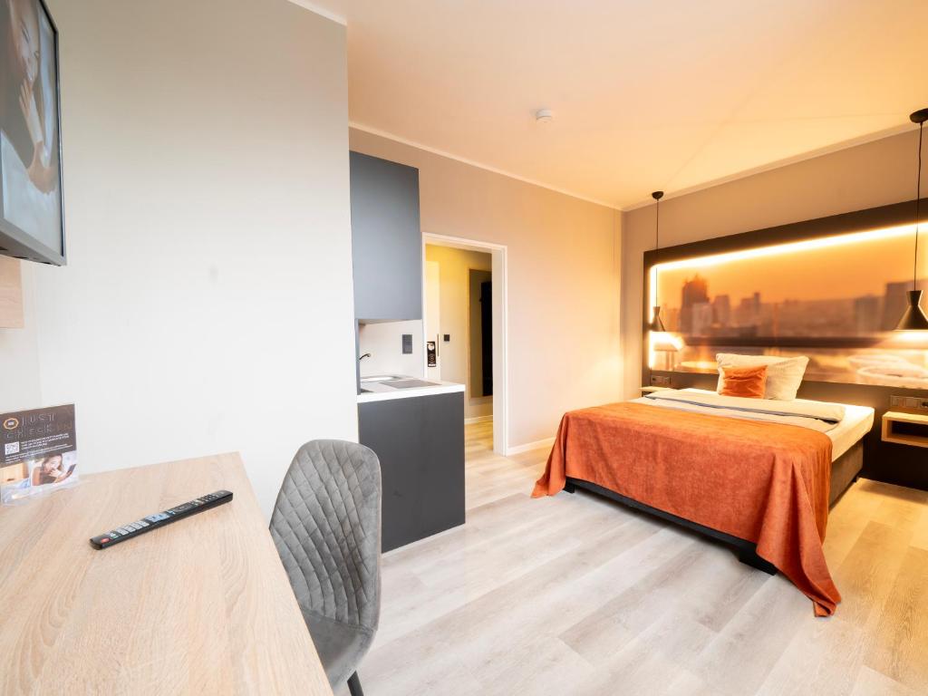 a hotel room with a bed and a kitchen at JustStay Mülheim Hotel & Apartments in Mülheim an der Ruhr