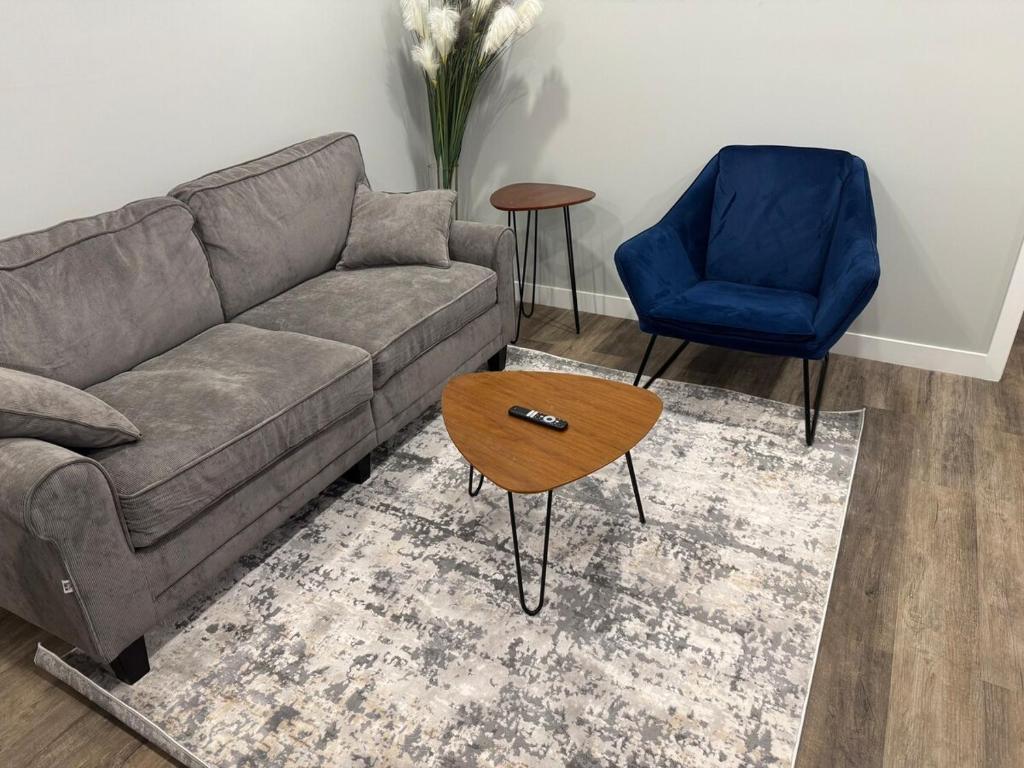 a living room with a couch and a blue chair at 1-Bedroom - On site Parking - near YQR Airport in Regina
