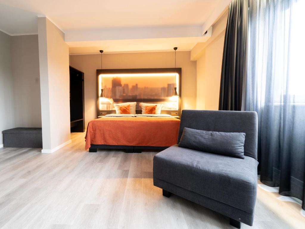 a hotel room with a bed and a chair at JustStay Mülheim Hotel & Apartments in Mülheim an der Ruhr
